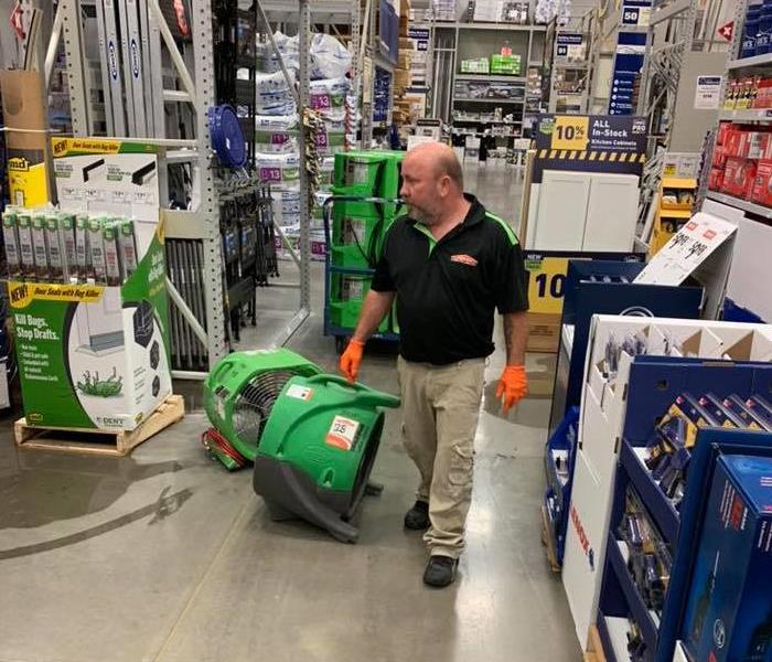 This is a picture of one of our techs in a Lowes cleaning up water damage.  he is in the flooring section of Lowes.